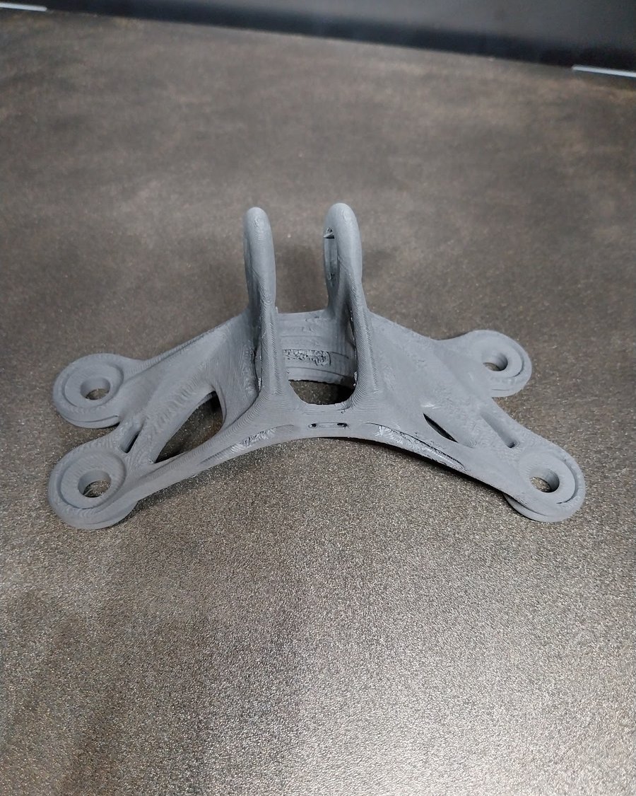 As-printed 316L stainless steel mounting bracket, produced via Bound Metal Deposition prior to sintering